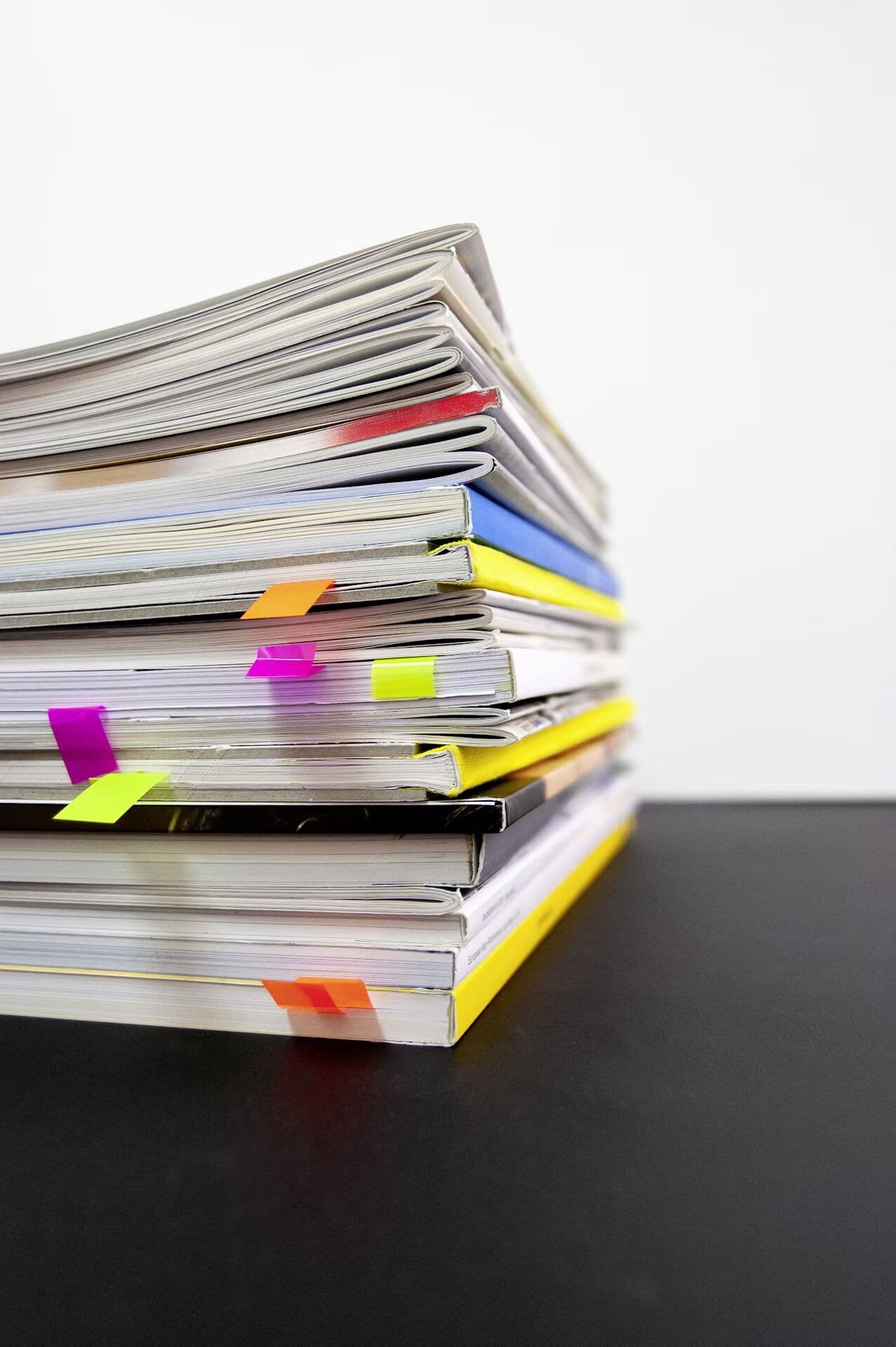 Stack of technical books with page markers