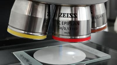 Microscope objective lens positioned over a cleanliness testing sample
