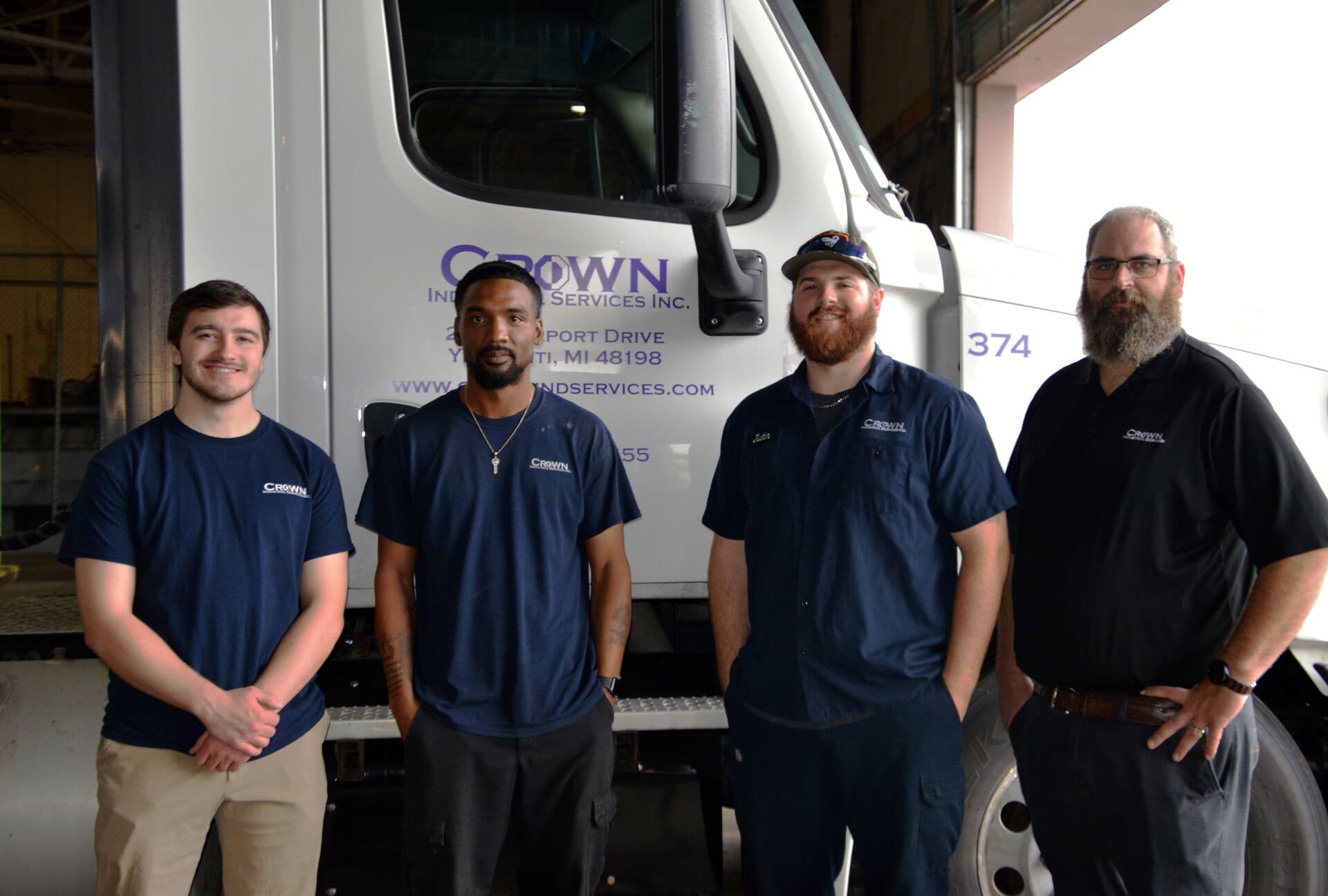 Crown Industrial Services team members standing beside a company truck