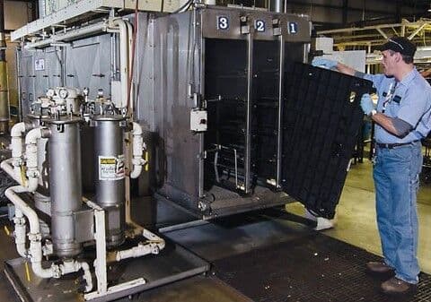 Operator loading reusable dunnage into a washing system