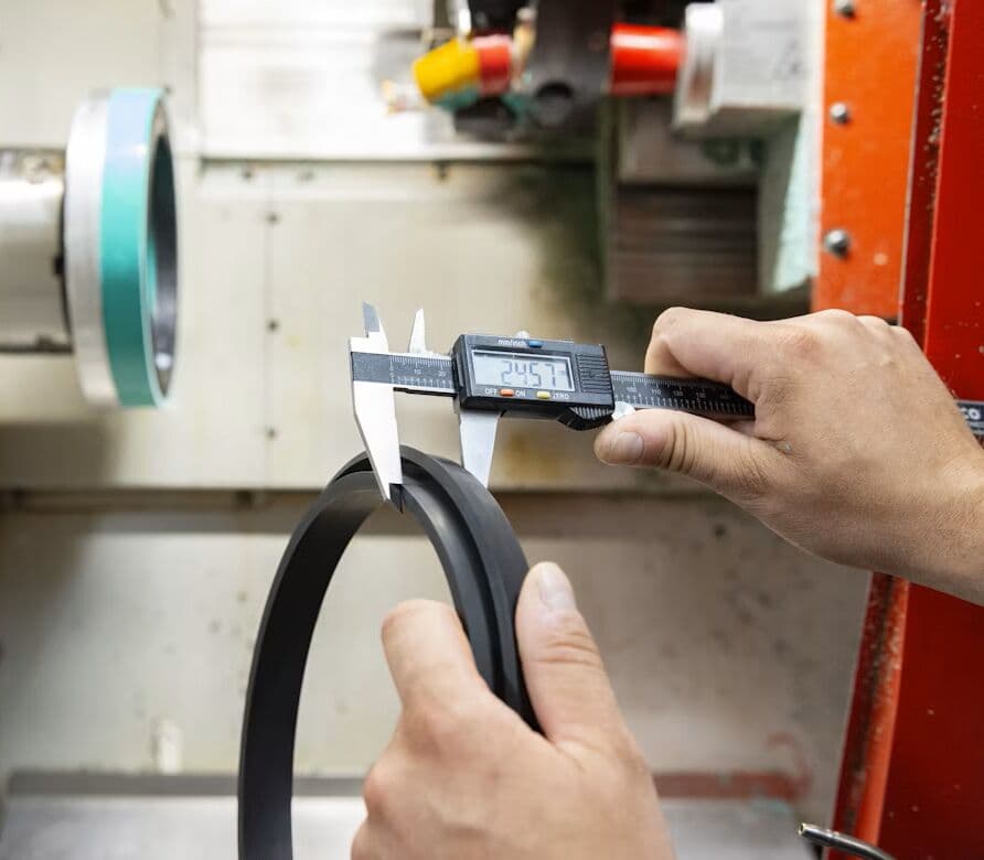 Technician measuring a machined component with calipers