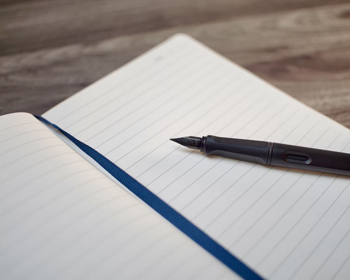 Open lined notebook with a pen