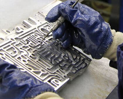 Technician manually cleaning a metal component