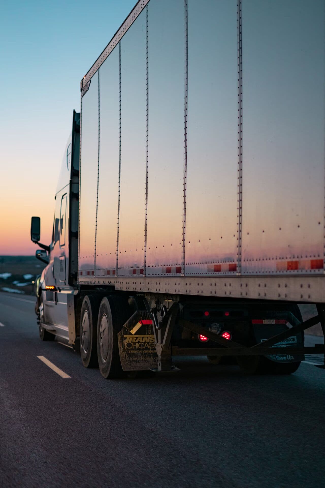 Semi-trailer traveling on a highway at sunset