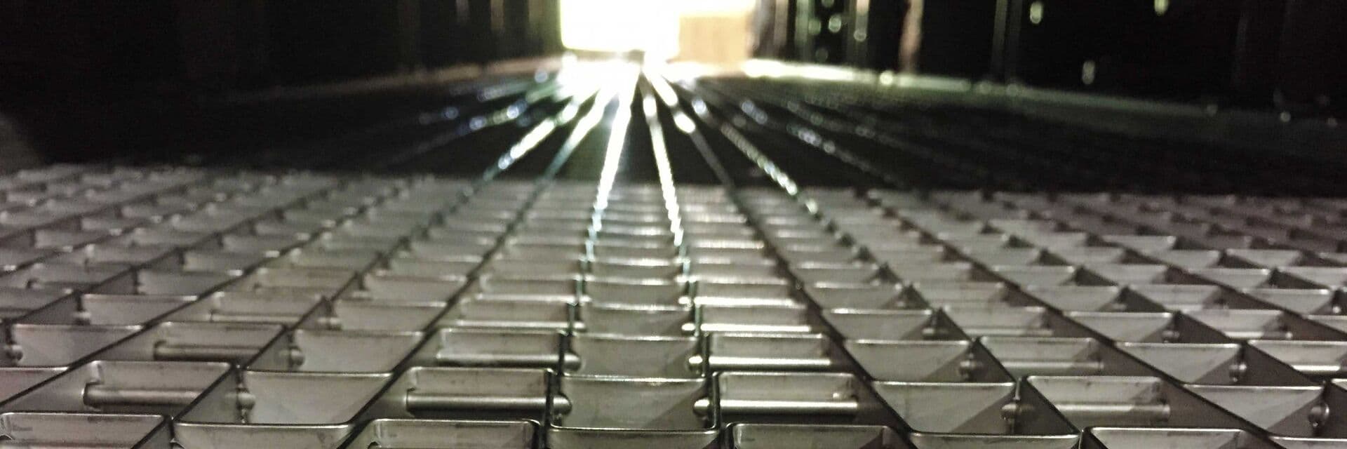 Conveyor belt inside an industrial parts washing system